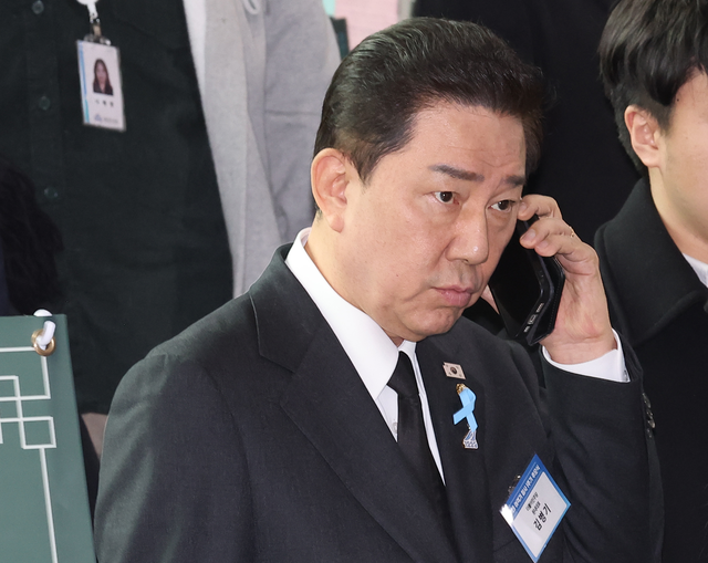 김병기 더불어민주당 원내대표가 29일 전라남도 무안군 무안국제공항 여객터미널에서 열린 12ㆍ29 여객기 참사 1주기 추모식을 마친 뒤 이동하며 전화 통화를 하고 있다. [연합뉴스]