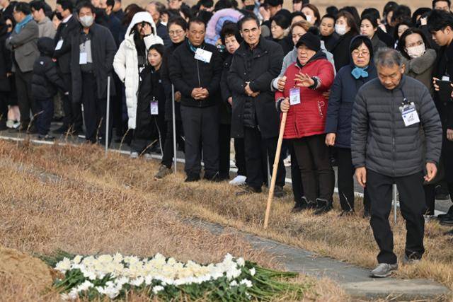 12·29 제주항공 여객기 참사 1주기인 29일 전남 무안국제공항 활주로 콘크리트 둔덕 주변에서 유가족들이 희생자들을 향해 쓴 편지를 불태우며 작별인사를 하고 있다. 무안=뉴시스