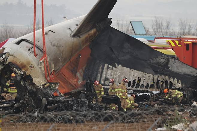 Firefighters conduct search and rescue operations at the wreckage site of the Jeju Air aircraft at Muan International Airport on Dec. 30, 2024. [EPA/YONHAP]