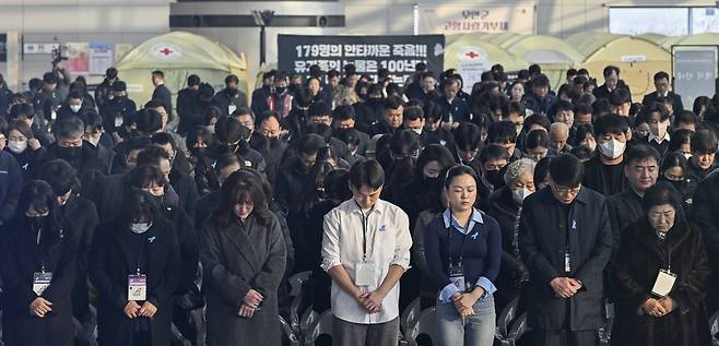 At 9:03 a.m. on Dec. 29, the time of the Jeju Air crash one year earlier, a memorial siren sounds at Muan International Airport in Muan County, South Jeolla as bereaved families and attendees bow their heads in silent tribute to the victims. [JOINT PRESS CORPS]