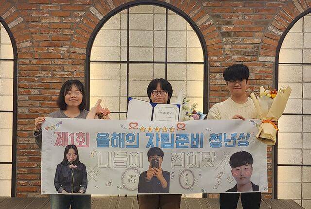 한국고아사랑협회가 27일 서울 금천구 아쿠아픽 코이노니아홀에서 ‘2025 올해의 자립준비청년상’ 시상식을 진행했다. 왼쪽부터 수상자인 최은진 서연지 이선씨가 꽃다발과 상장, 플래카드를 들어 보이고 있다.