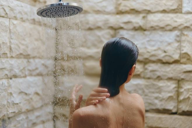 자연광이 드는 공간에서 샤워를 하는 모습. 샤워 시간은 개인의 생활 패턴과 피부·수면 상태에 따라 달라질 수 있다. ⓒ123rf