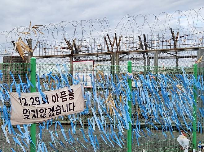 12월 28일 오후 제주항공 여객기 참사 현장에서 가장 가까운 무안국제공항 외곽 철조망에 '1229의 아픔을 잊지않겠습니다'라는 현수막이 걸려 있다. ⓒ시사저널 정성환