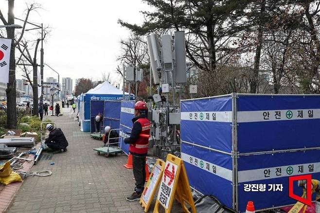 윤석열 대통령 탄핵소추안 재표결을 앞둔 12일 서울 여의도 국회 인근에서 통신사 작업자들이 원활한 통신 사용을 위해 기지국을 설치하고 있다. 강진형 기자