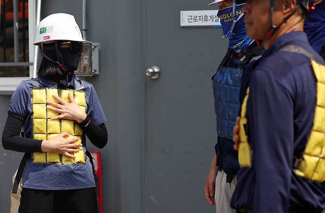 2024년 8월 6일 광주광역시 북구청 신관 공사 현장에서 작업자들이 근로자 휴게실에서 냉조끼를 착용하고 휴식을 취하고 있다. 사진은 기사 내용과 직접적인 관련 없음. /광주 북구 제공