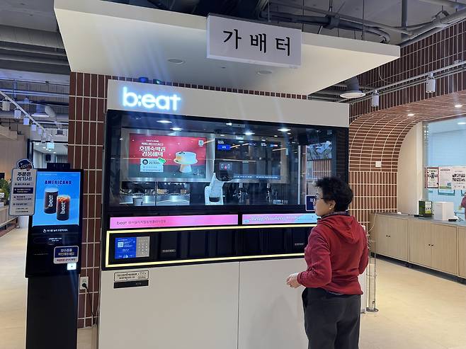 A visitor at Seoul Inclusive Digital Plaza in Gangdong District, eastern Seoul, waits for coffee made by a robotic arm on Dec. 18. [CHO JUNG-WOO]