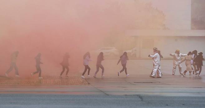 People are seen running from smoke during an aviation disaster exercise held jointly with the Ministry of Land, Infrastructure and Transport and domestic airlines at Incheon International Airport on May 17, 2018. [JOONGANG ILBO]