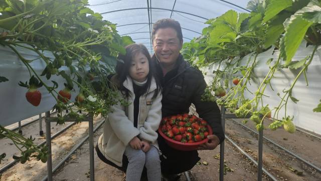 오명한씨가 딸 지수 양과 함께 딸기 하우스에서 포즈를 취하고 있다.