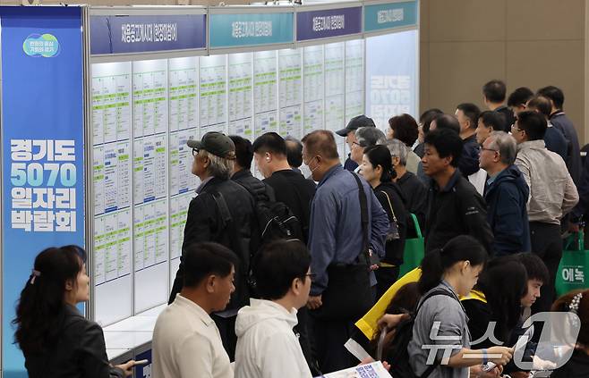 경기도 일산 킨텍스 제2전시장에서 열린 ‘경기도 5070 일자리 박람회’를 방문한 구직자들이 구인공고를 살펴보고 있다.  ⓒ News1 이호윤 기자