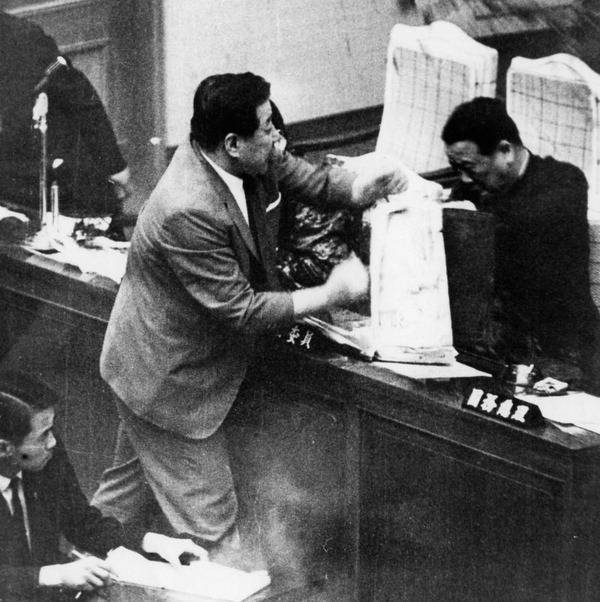 김두한 의원이 국회에서 정부 각료를 향해 오물을 뿌리고 있다.  국제신문DB