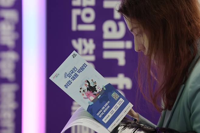 A jobseeker looks through a pamphlet on Dec. 20 during a job fair held for foreigners in Gangnam-gu, Seoul. (Yonhap)