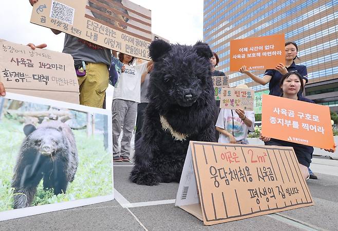 Members of civic groups, including Green Korea United, stage a performance, calling on the Environment Ministry to take greater responsibility in ending the bear farming industry, during a press conference at Gwanghwamun Square in central Seoul on July 22. The bear farming industry is set to be phased out on Dec. 31, following a revision to the law. [YONHAP]