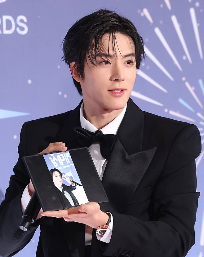 Eric of The Boyz poses on the red carpet at the 2025 MBC Entertainment Awards in Seoul after taking a selfie with Samsung’s Galaxy Z TriFold smartphone. (News1)
