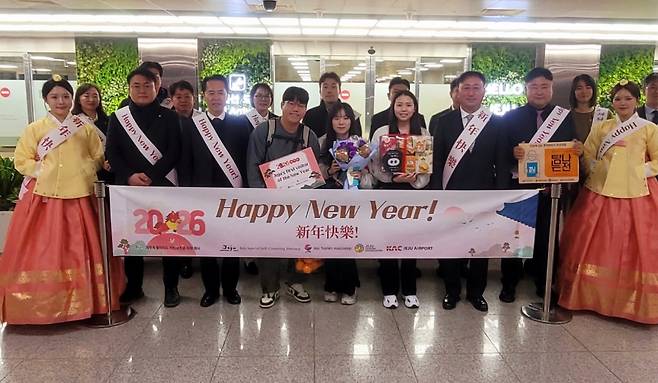 새해 첫날 제주국제공항에서 열린 입도 관광객 환영 행사에서 관계자들과 첫 방문객들이 기념 촬영을 하고 있다. (제주도관광협회 제공)