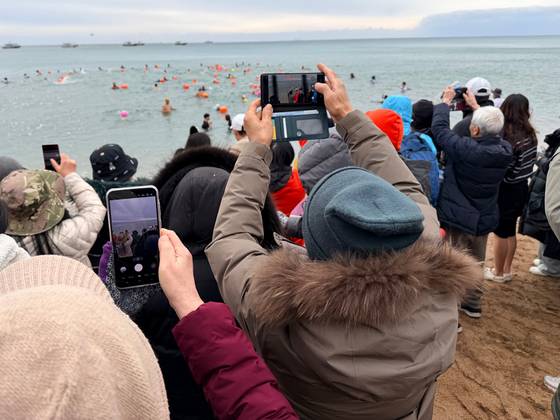 1일 낮 12시 제27회 서귀포 겨울바다 국제펭귄수영대회 참가자들의 지인들이 입수 참가자들의 사진을 찍고 있다. 최충일 기자 최충일 기자