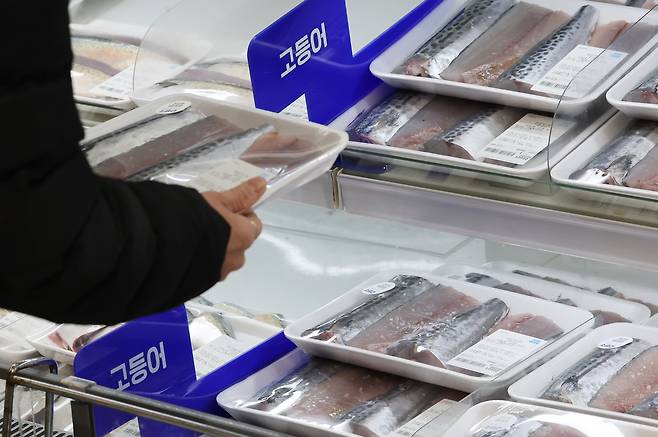 A customer selects mackerel at a supermarket in Seoul on Dec. 31, 2025. [NEWS1]
