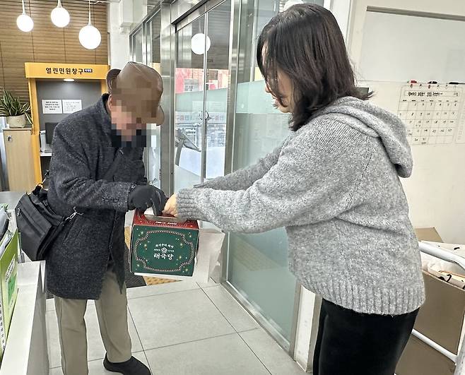 중구 직원이 한 어르신에게 태극당 케이크를 전달하고 있다. [중구 제공]