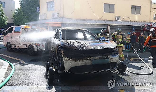 충전 중 불 난 전기차 (창원=연합뉴스) 김동민 기자 = 29일 오전 경남 창원시 마산합포구 한 오피스텔 지하 주차장에서 충전 중인 전기차에서 화재가 발생, 소방대원이 견인해 지상으로 옮긴 화재 차량의 잔불 작업을 하고 있다. 2025.10.29 image@yna.co.kr