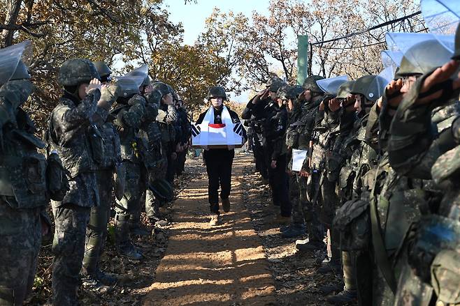 South Korean soldiers salute as the flag-draped remains of a soldier killed in the Korean War (1950-53) are carried from the Baekma-Goji excavation site inside the DMZ on Dec. 1, 2025. Over a 40-day excavation, the military recovered 25 sets of remains and nearly 2,000 artifacts from this former battlefield in Cheorwon, Gangwon, part of efforts to transform the DMZ into a zone of peace. A senior national security official’s visit here was recently blocked by the UNC, sparking controversy. [MINISTRY OF NATIONAL DEFENSE]