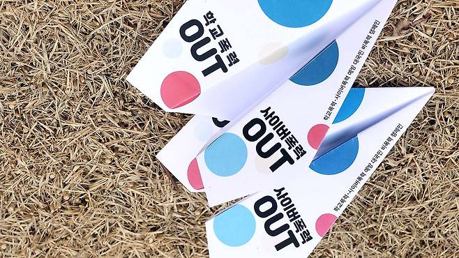 Paper airplanes saying “school violence out” lie on the ground at Hanbit Square at Cheonggyecheon in Seoul after being launched by participants as part of a campaign against school and cyber violence in 2023. [YONHAP]