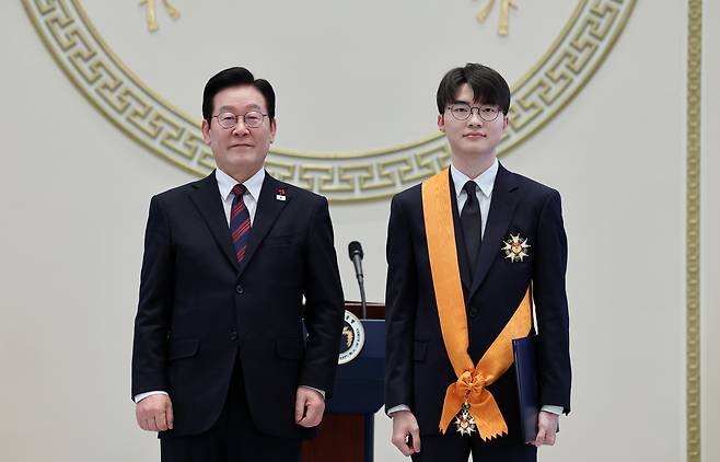 President Lee Jae Myung, left, poses with Lee Sang-hyeok, the League of Legends world champion better known as “Faker,” after presenting him with the Cheongnyong Medal, the nation’s highest sporting honor, during the 2026 New Year’s gathering at the state guesthouse of the Blue House in central Seoul on Jan. 2. [NEWS1]