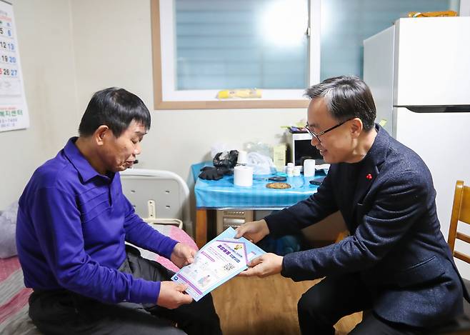 유성훈 금천구청장(오른쪽)이 보라색 상의를 입은 남성에게 서류를 전달하고 있는 사진이다. 유성훈 금천구청장은 검정색 정장을 입고 안경을 쓴 채 미소를 짓고 있다.