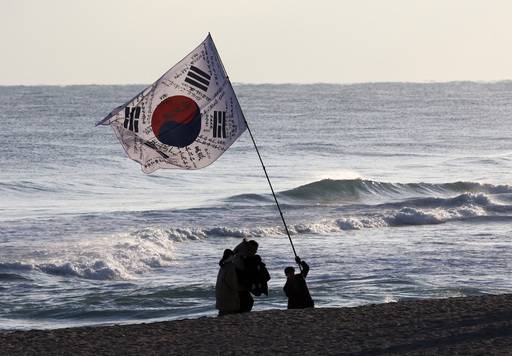 2026년 병오년 새해 첫날인 1일 강원 강릉시 경포해변에서 한 시민이 대형 태극기를 흔들고 있다. 연합뉴스 제공