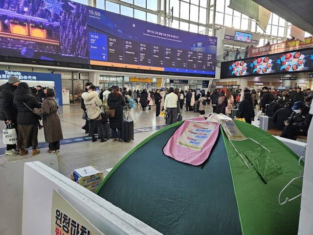 서재유 전국철도노조 코레일네트웍스지부 수석부지부장이 2025년 12월31일 서울역 대합실에서 단식농성을 하고 있다. 단식농성 텐트 앞으로 수많은 사람이 지나가고 있다. 류석우 기자