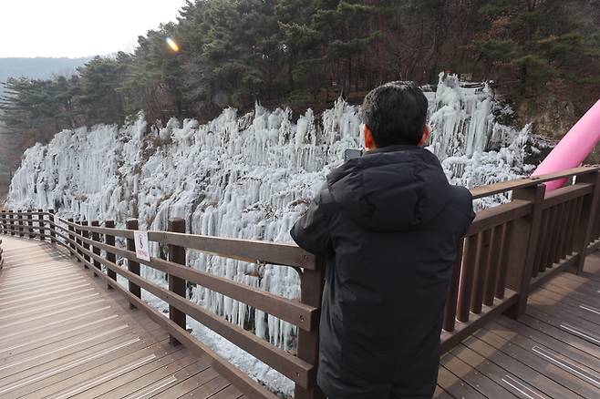 ▲ 절기상 소한(小寒)을 하루 앞둔 4일 오전 대구 달성군 옥연지 송해공원을 찾은 한 관광객이 빙벽을 감상하고 있다.김영환 기자yhk@kyongbuk.com