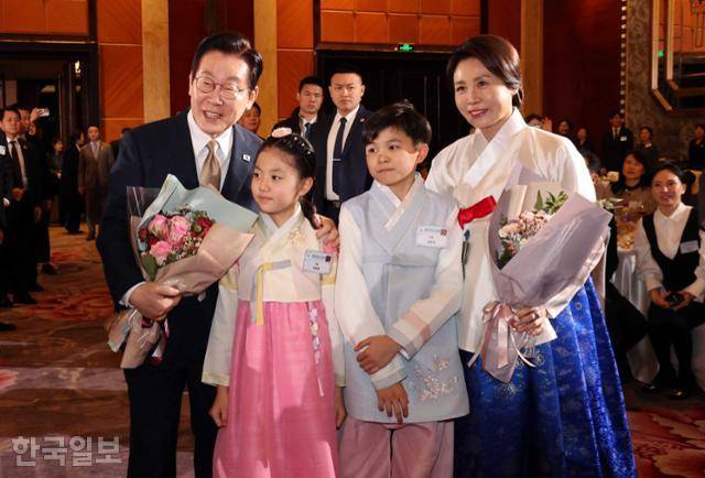 이재명 대통령과 김혜경 여사가 4일 중국 베이징의 한 호텔에서 열린 동포 만찬간담회에서 화동으로부터 꽃다발를 받은 뒤 기념사진을 찍고 있다. 베이징=왕태석 선임기자