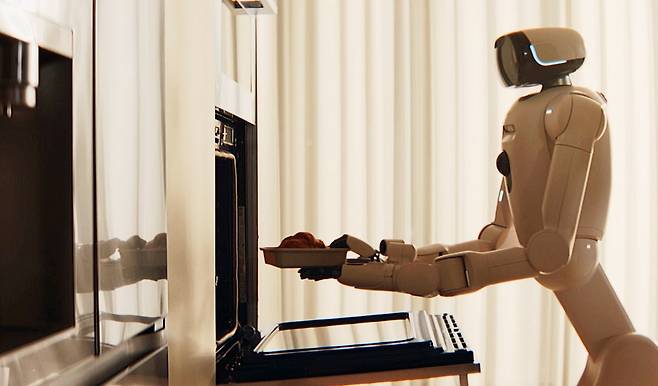 LG 클로이드가 크루아상을 오븐에 넣으며 식사를 준비하고 있다. 사진=LG전자 제공