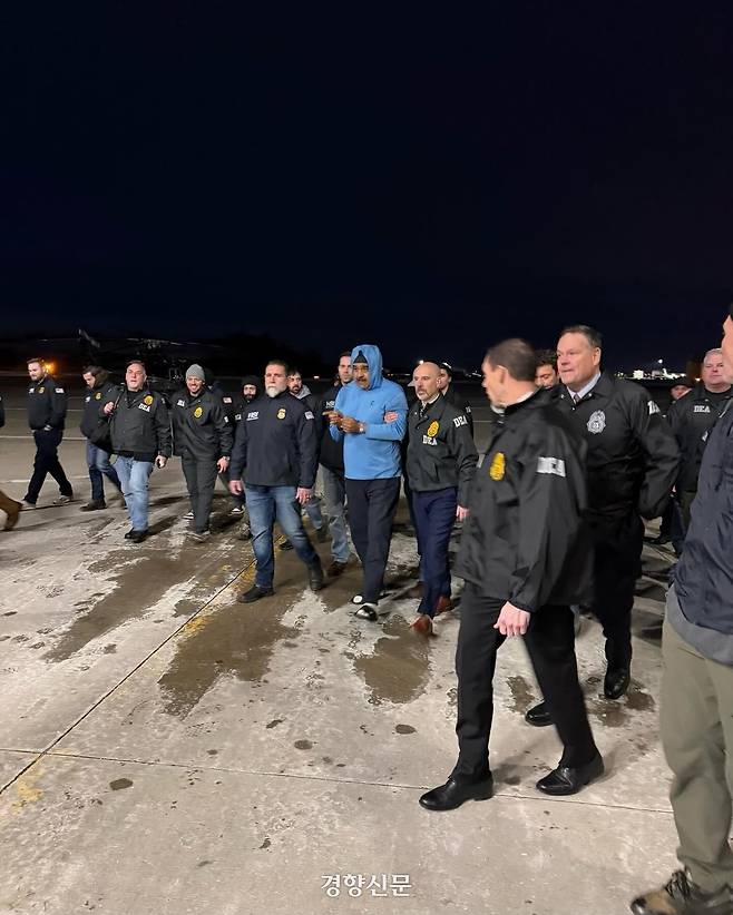 니콜라스 마두로 베네수엘라 대통령이 미국 뉴욕주 스튜어트 공군 기지에 도착한 후 마약단속국 요원들과 함께 이동하고 있다. 지난 3일(현지시간) 새벽 베네수엘라에서 배우자 실리아 플로레스와 함께 체포된 마두로 대통령은 미국에서 마약 테러 혐의 등으로 기소될 예정이다. SNS 갈무리