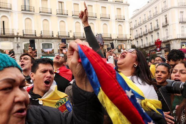 미국이 3일 니콜라스 마두로 베네수엘라 대통령을 생포했다는 소식이 도널드 트럼프 미 대통령에 의해 전해지자 스페인 마드리드에 모인 사람들이 기뻐하고 있다. 마드리드=로이터 연합뉴스