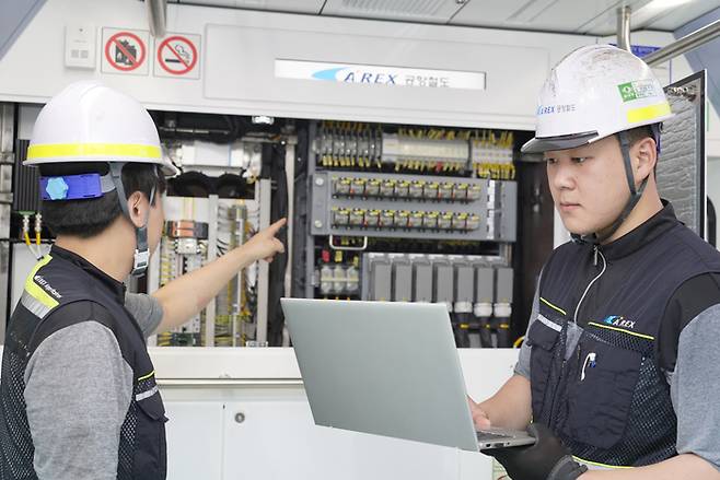 용유차량기지에서 공항철도 직원들이 5G 특화망에 연결된 노트북을 통해 객차 및 설비를 점검하는 모습.