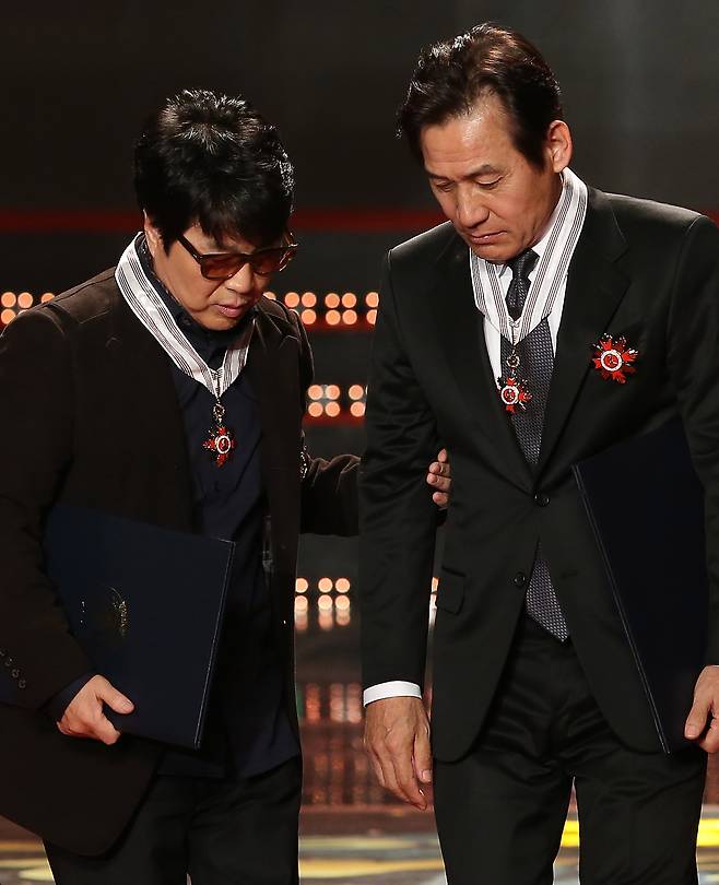 Ahn Sung-ki (right) and singer Cho Yong-pil receive the Silver Crown of the Order of Cultural Merit at the 2013 Korean Popular Culture and Arts Awards. The longtime friends of more than six decades attended Kyungdong Middle School together in Seoul. (Yonhap)