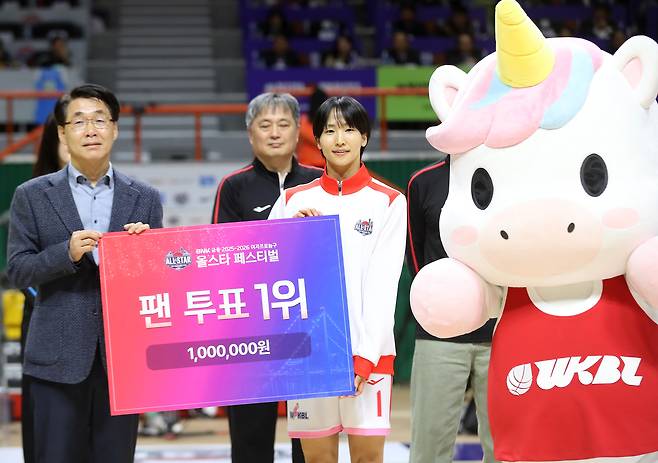 Saki Iijima, center, of Team Unibl receives a trophy for topping the fan vote ahead of the WKBL All-Star Festival game between Team Unibl and Team Ponibl at Sajik Gymnasium in Busan on Jan. 4. [NEWS1]