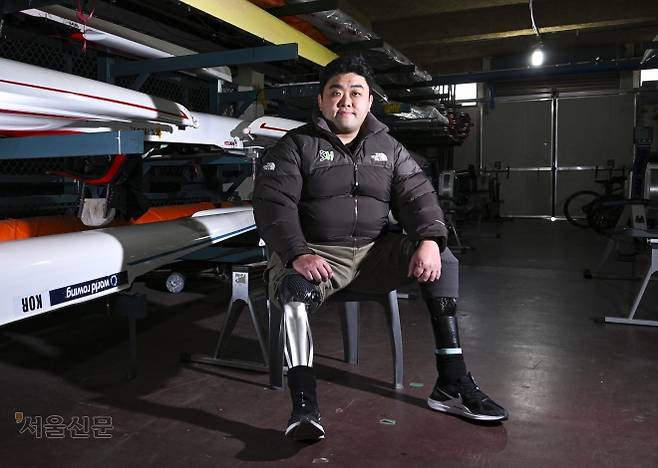 서울주택도시개발공사(SH) 장애인조정팀의 하재헌 선수가 지난해 12월 30일 경기 하남 미사리조정경기장에 보관된 조정 장비 옆에 바지를 걷어 올리고 앉았다. 2015년 목함지뢰 사고로 두 다리를 잃은 그는 24차례의 수술과 지난한 재활을 딛고 조정 선수로 인생 2막을 살고 있다. 이지훈 기자