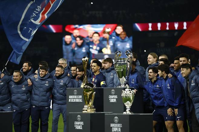 PSG 선수들이 5일 파리FC전 후 지난 1년간 들어올린 우승 트로피 앞에서 포즈를 취하고 있다. 이날 경기에 결장한 이강인(오른쪽 끝)도 동료와 함께 활짝 웃었다. EPA연합뉴스