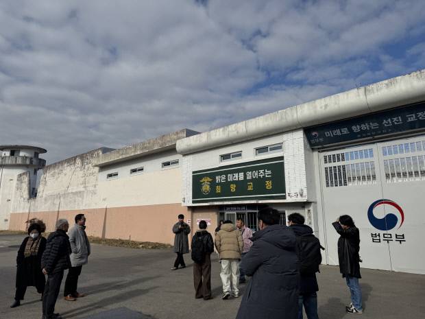 단체 방문객들이 옛 장흥교도소 정문을 배경으로 기념사진을 촬영하고 있다.