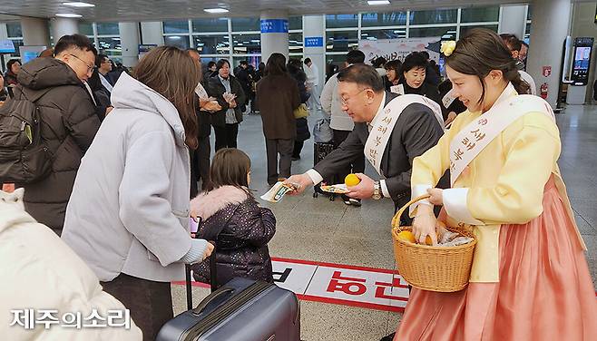 제주도관광협회가 새해 첫날인 1일 제주국제공항에서 관광객에게 감귤 등을 나눠주며 환영행사를 하고 있다. ⓒ제주의소리 자료사진