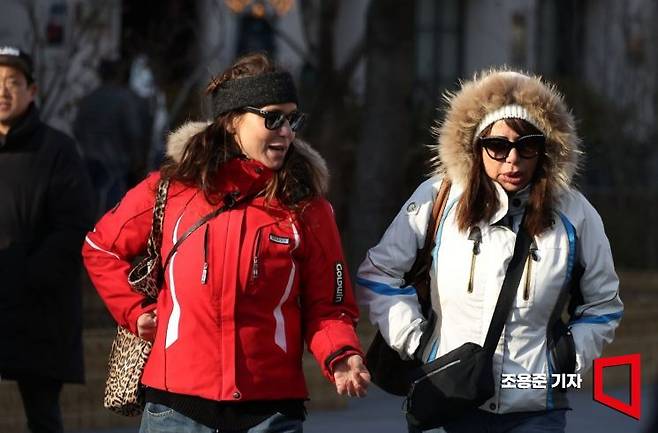 바람이 강하게 불며 다시 강추위가 몰려온 26일 오후 서울 종로구 세종대로에서 관광객들이 두툼한 옷차림으로 이동하고 있다. 기상청은 이날 오후부터 기온이 뚝 떨어져 내일 아침기온이 영하 7도까지 내려가 강추위가 오겠다고 예보했다. 조용준 기자