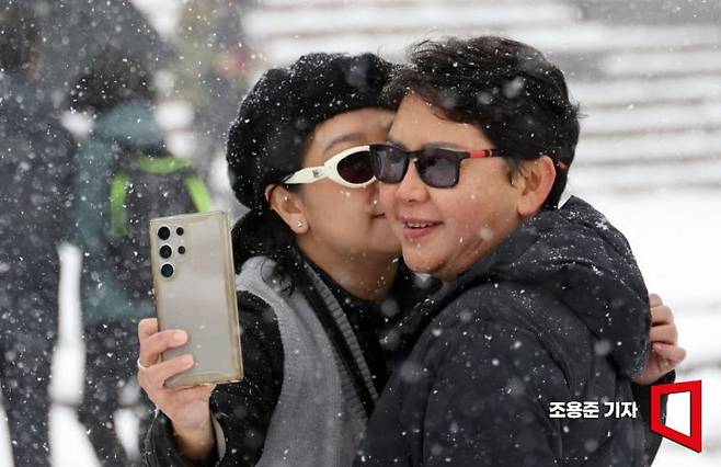 서울에 20cm에 이르는 폭설이 내린 27일 서울 중구 남산 전망대를 찾은 외국인 관광객이 기념사진을 찍고 있다. 조용준 기자