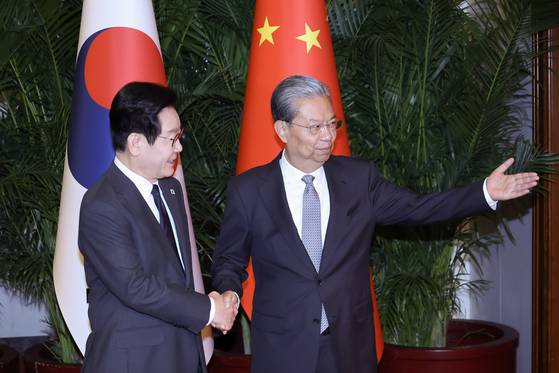 이재명 대통령이 6일 중국 베이징 인민대회당에서 자오러지 전인대 상무위원장의 영접을 받고 있다. 청와대사진기자단