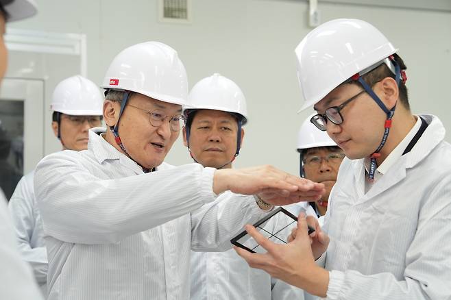 SK On CEO Lee Seok-hee (left) discusses vanadium-ion battery technology with employees. (SK On)