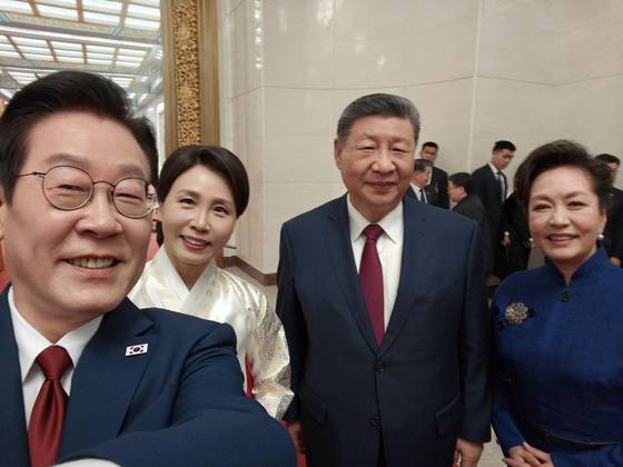 From left, President Lee Jae Myung, first lady Kim Hea Kyung, Chinese President Xi Jinping and first lady Peng Liyuan pose for a selfie taken by Lee on a Xiaomi smartphone during a state dinner at the Great Hall of the People in Beijing on Jan. 5. [BLUE HOUSE]