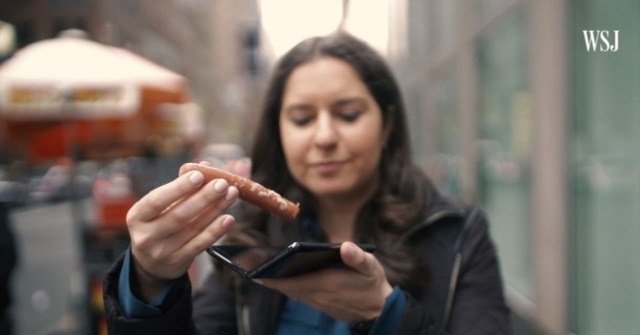 월스트리트저널(WSJ)의 테크 칼럼니스트 조안나 스턴이 삼성 폴더블폰 ‘갤럭시 폴드’에 소시지를 끼워 넣는 퍼포먼스를 하며 조롱하는 모습. [유튜브 갈무리]