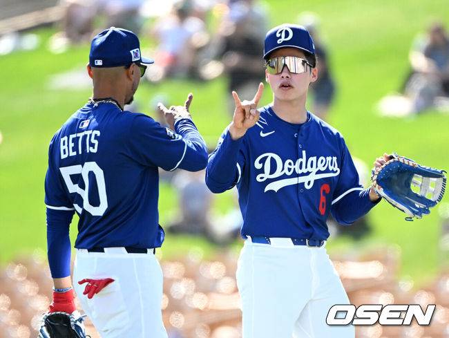 [OSEN=애리조나(미국), 이대선 기자] 21일(한국시간) 미국 애리조나주 글렌데일 캐멀백 랜치에서 2025 메이저리그 LA 다저스와 시카고 컵스의 시범 경기가 열렸다.김혜성은 다저스와 최대 3+2년 2200만 달러(약 320억원) 계약에 합의하며 메이저리그 진출에 성공했다.LA 다저스 김혜성이 무키 베츠와 사인을 교환하고 있다.  2025.02.21 / sunday@osen.co.kr