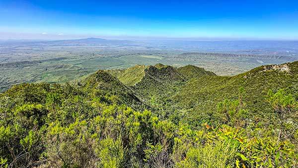 롱고놋산 정상에서 내려다본 풍경. 분화구 능선 너머로 동지구대가 길게 펼쳐지고 초록의 주름진 대지가 이어진다.