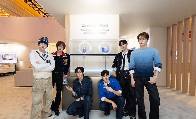 K팝 아티스트 라이즈(RIIZE)가 삼성전자 '더 퍼스트룩' 단독 전시관에서 두 번 접는 폴더블폰 '갤럭시 Z 트라이폴드'를 소개하고 있다.