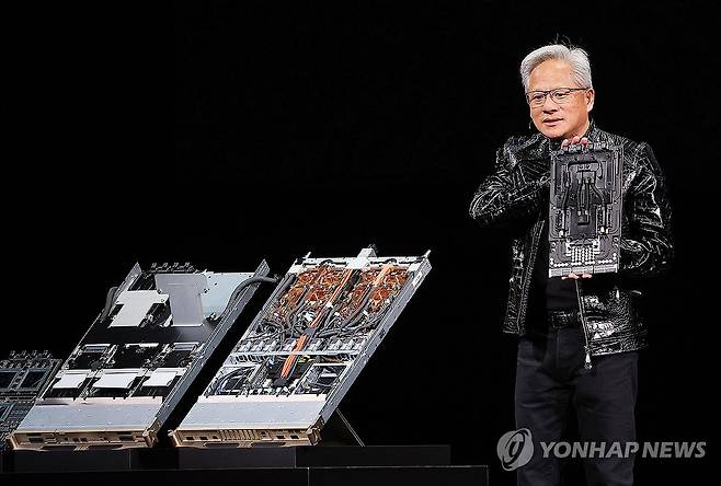 AI 가속기 들어 보이는 젠슨 황 (라스베이거스=연합뉴스) 김성민 기자 = 젠슨 황 엔비디아 CEO가 5일(현지시간) 미국 네바다주 라스베이거스 퐁텐블로 호텔에서 열린 엔비디아 CES 2026 라이브에서 기조연설 도중 AI 가속기를 들어 보이고 있다.  2026.1.6 ksm7976@yna.co.kr
